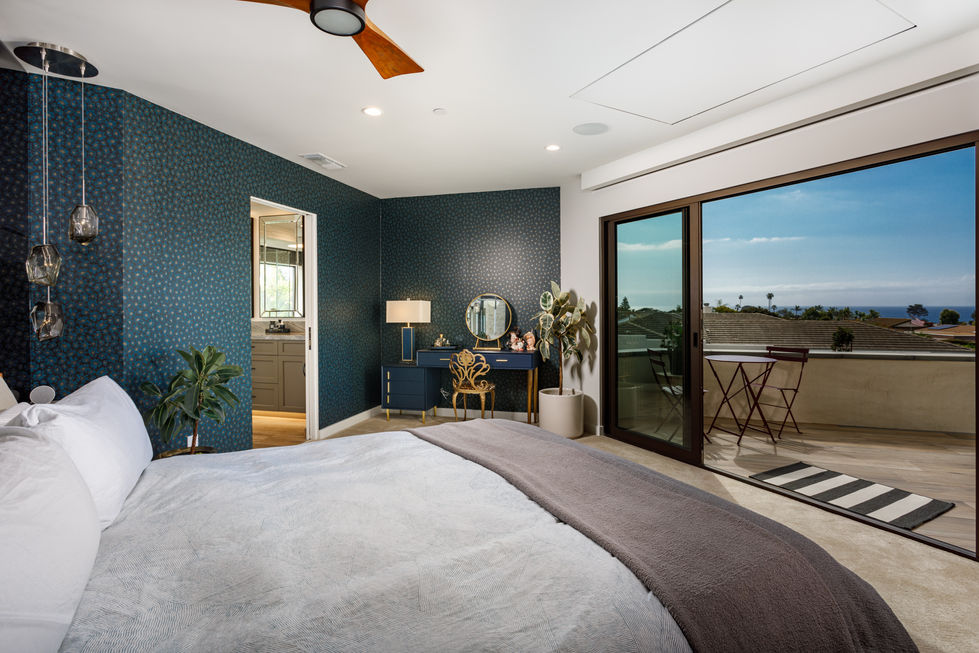 a bedroom with a sliding glass door leading to a balcony