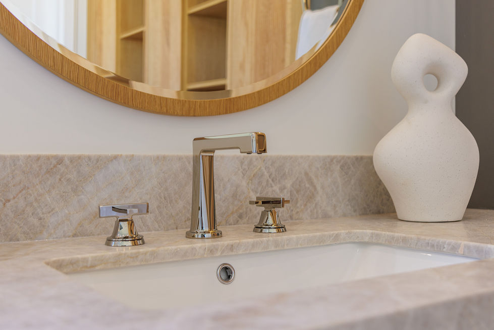 a bathroom sink with a round mirror above it