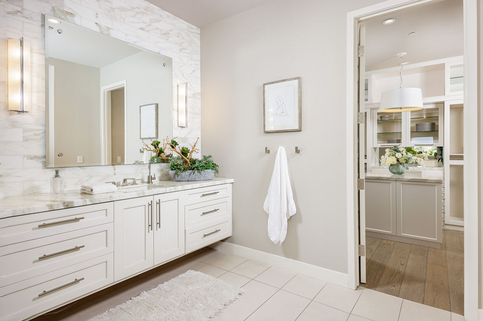 a bathroom with white cabinets and a large mirror