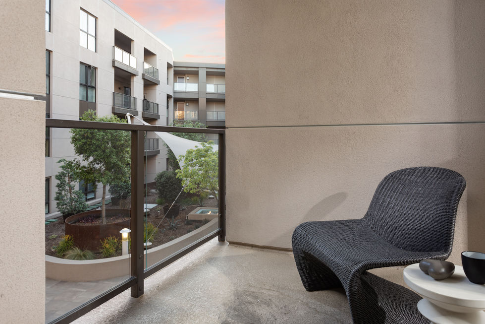 a balcony with a chair and a view of a building