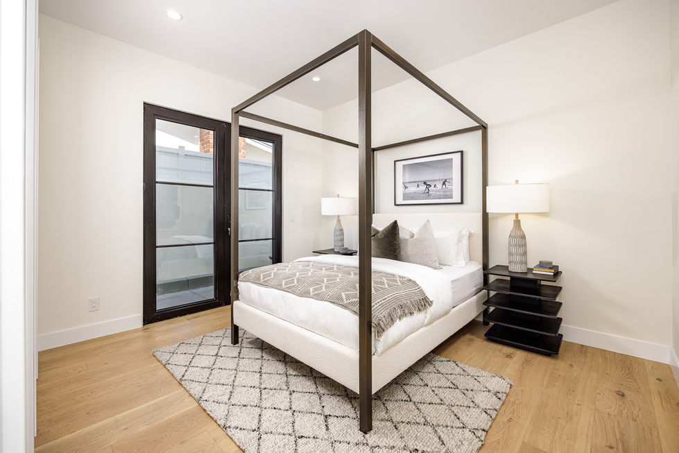 a bedroom with a canopy bed and a picture on the wall