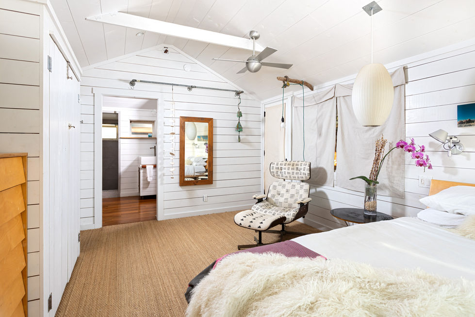 a bedroom with a chair and a mirror on the wall