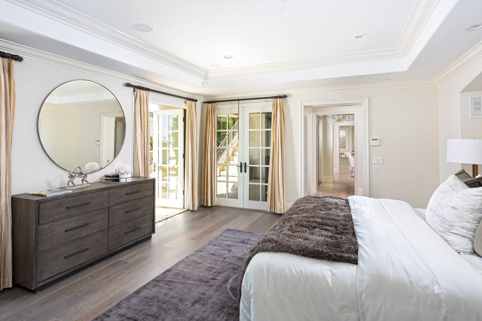 a bedroom with a bed a dresser and a mirror