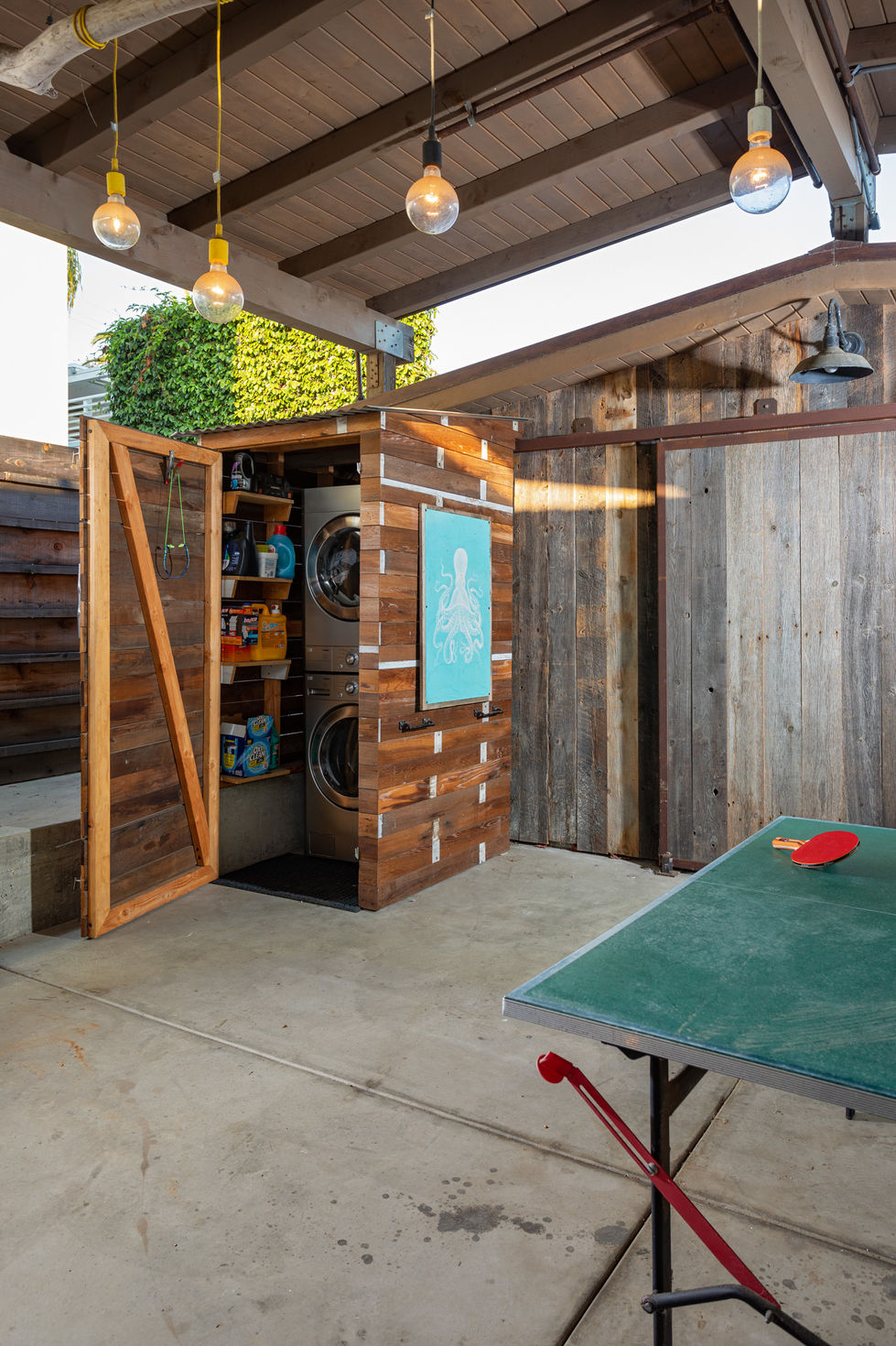 a wooden shed with a washer and dryer inside of it
