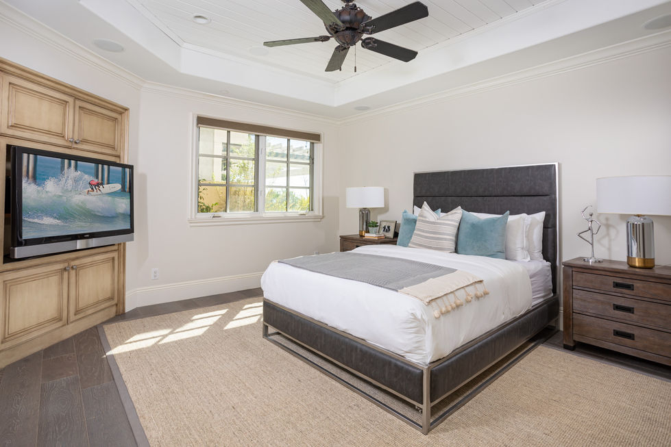 a bedroom with a large bed and a ceiling fan