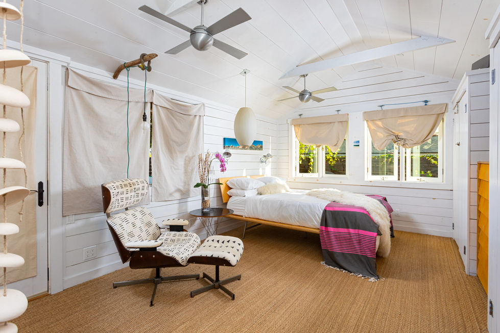 a bedroom with a bed a chair and a ceiling fan