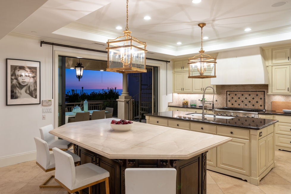 a kitchen with a large island with a bowl of fruit on it