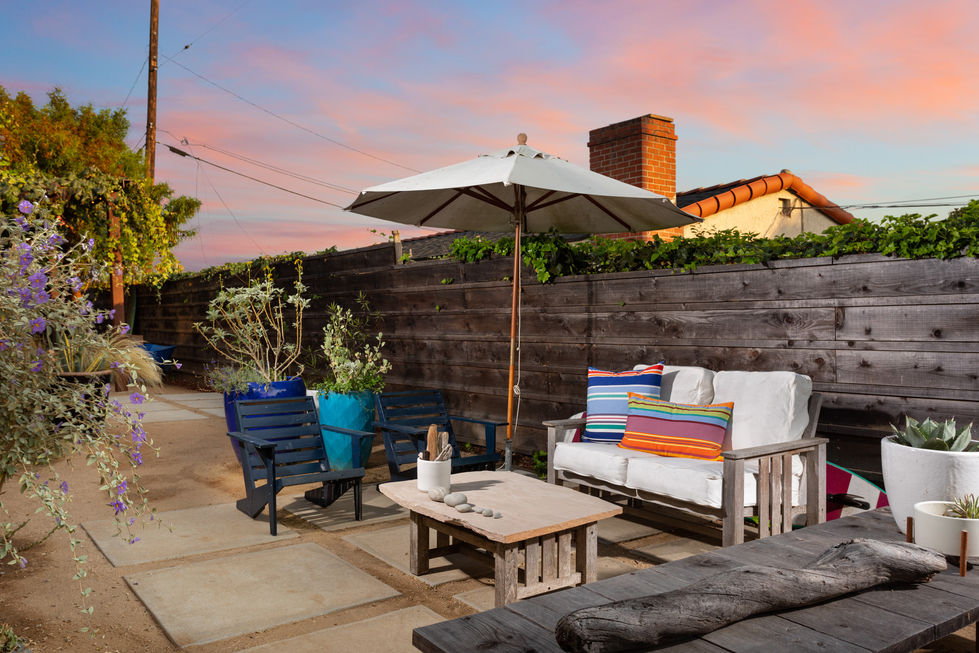 a patio with a white umbrella and a couch