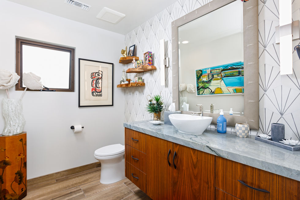 a bathroom with a toilet a sink and a painting on the wall