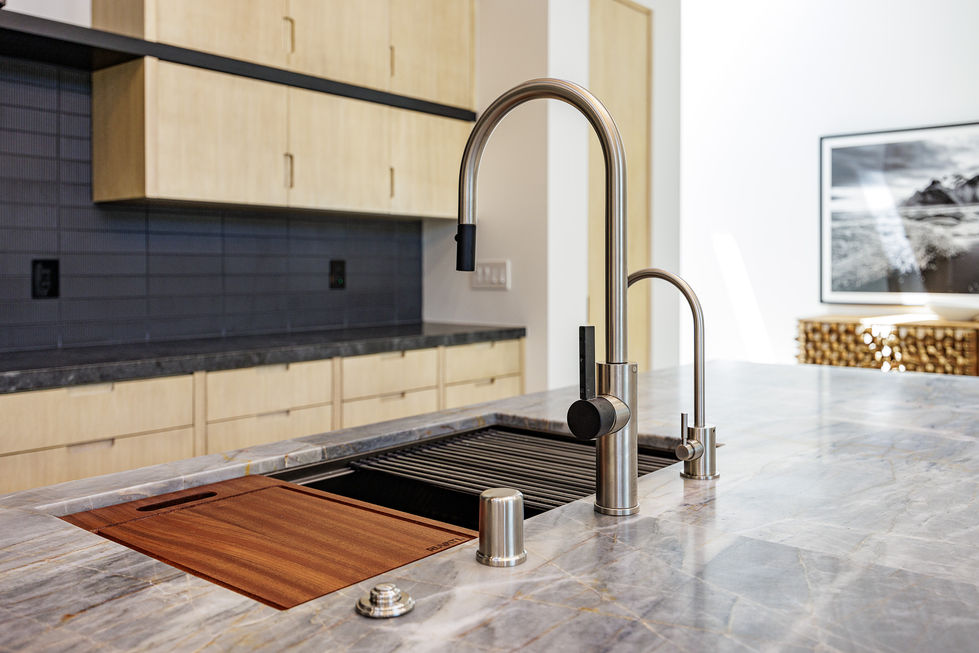 a kitchen sink with a wooden cutting board underneath it