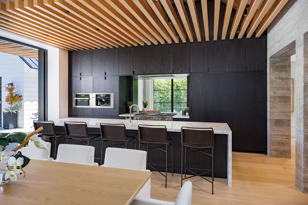 a kitchen with black cabinets and a wooden ceiling