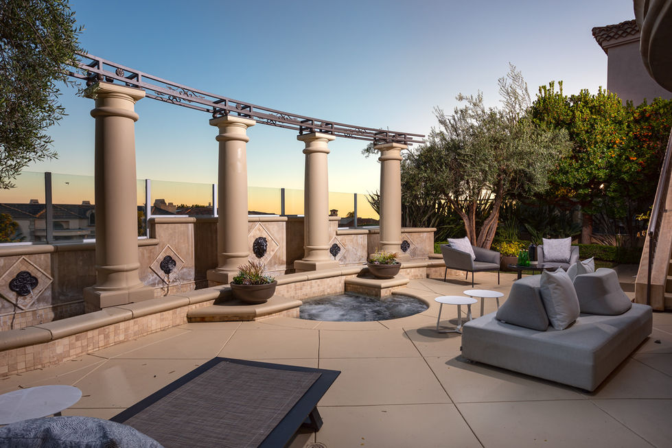 a patio area with columns and a hot tub