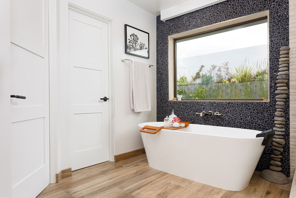 a bathtub in a bathroom with a picture on the wall above it