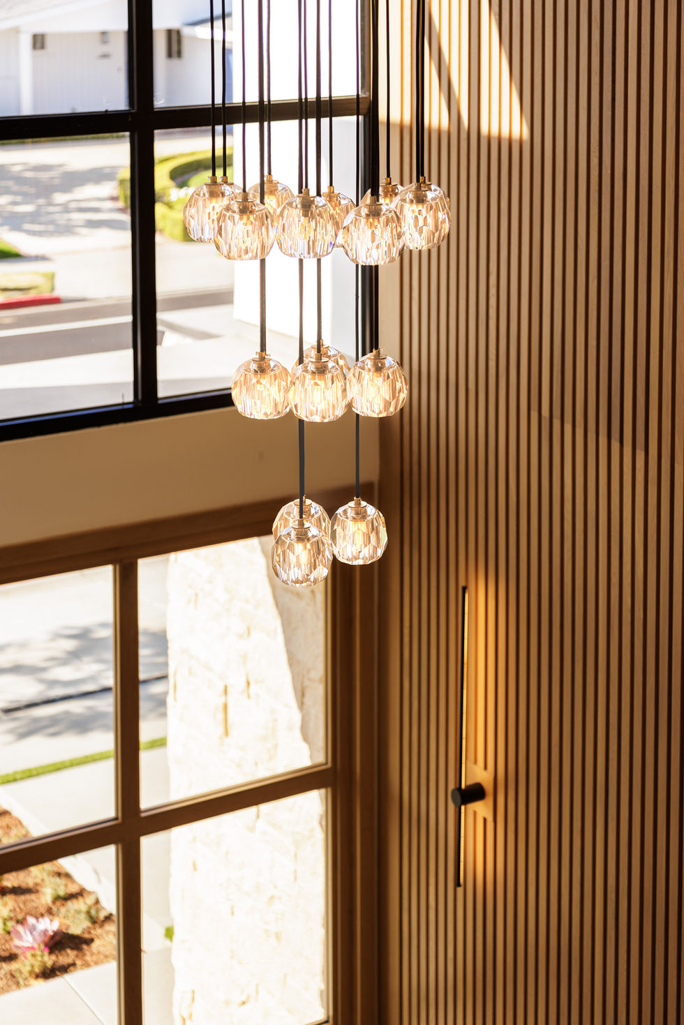 a cluster of lights hanging from the ceiling in front of a window