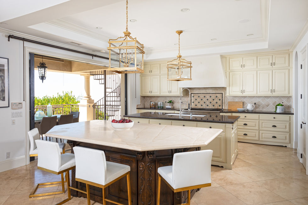 a kitchen with a large island with a bowl of fruit on it