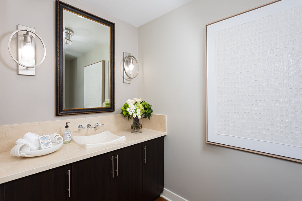 a bathroom with a sink a mirror and a picture on the wall