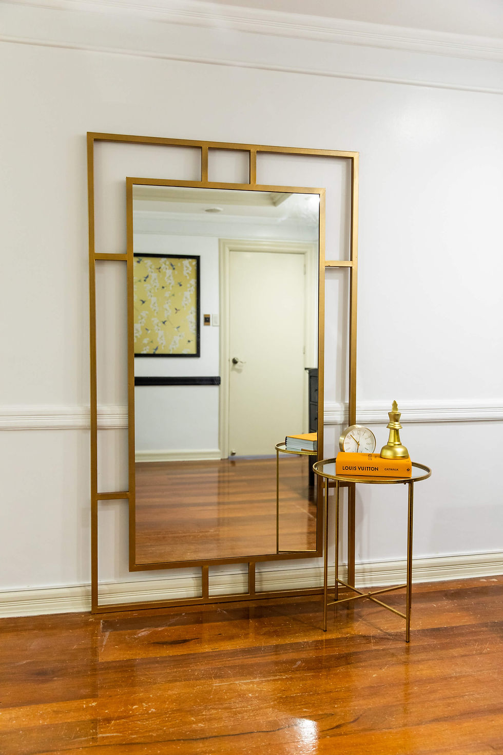 A large golden framed mirror against a wall