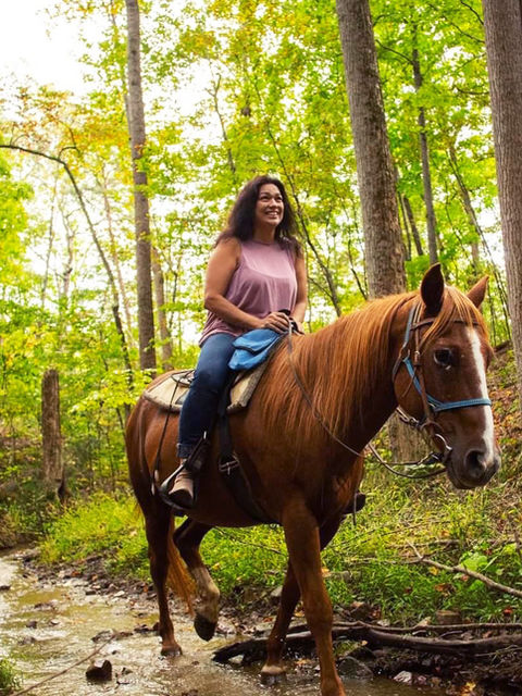 Sun shining through the trees while crossing a creek - Scenic trail ride at Fort Valley Ranch & Campground winding through the picturesque trails of a National Park, surrounded by breathtaking mountain views near Shenandoah National Park.