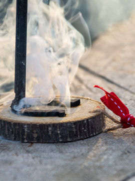 Christmas Ornament Branding - Guests branding wooden ornaments over a blazing campfire, creating personalized keepsakes at the campground.