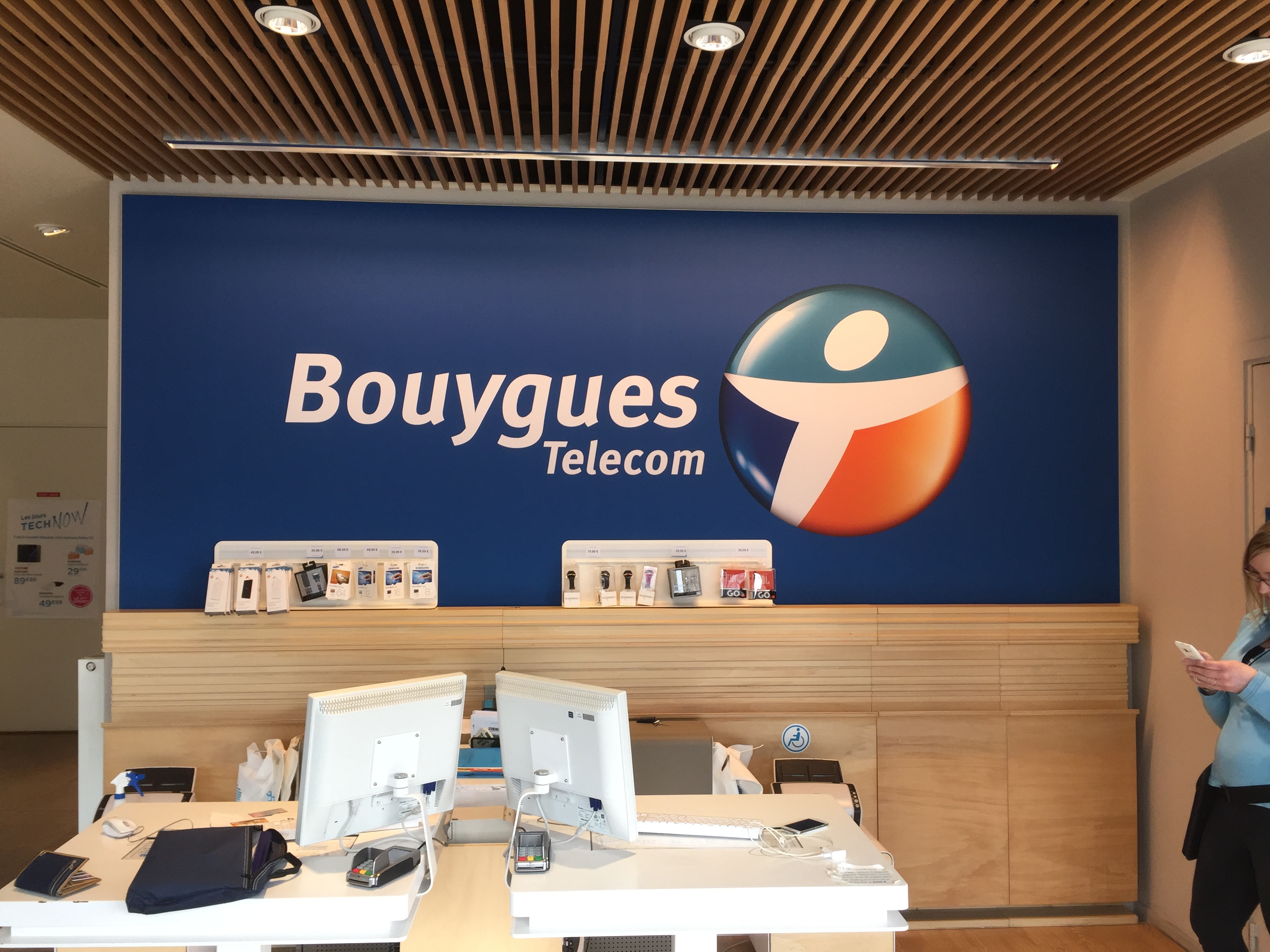 Habillage mural intérieur bleu avec logo Bouygues Telecom réalisé par Peppergraphik dans une boutique au Havre