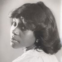 Nadeen Campbell wearing a white blouse gazes over her shoulder in a monochrome portrait, .