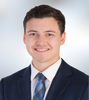 Female headshot with white shirt and dark hair up in bun