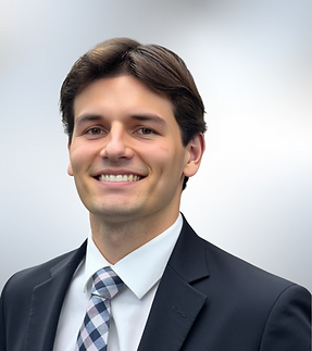 Female headshot with white shirt and dark hair up in bun