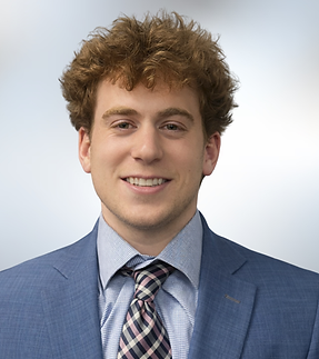 Female headshot with white shirt and dark hair up in bun