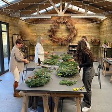 Workshop attendees making wreathes on tables in the centre of the studio