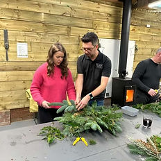 Ryan helping a worskhop attendee makinga wreath