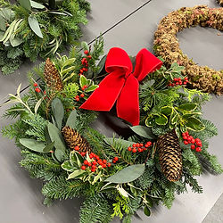 A complete Christmas wreath with red berries and a big red velet bow.