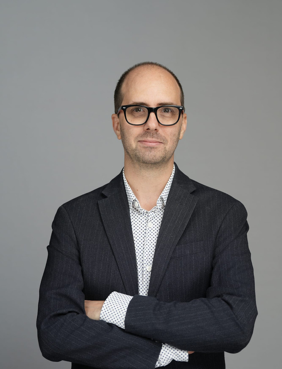 Aurelien Mangano, executive leadership coach and founder of DevelUpLeaders, arms crossed in a tailored blazer