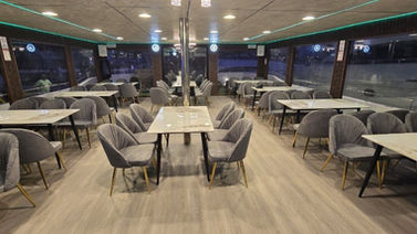 Indoor dining saloon seating on a shared yacht cruise in Dubai