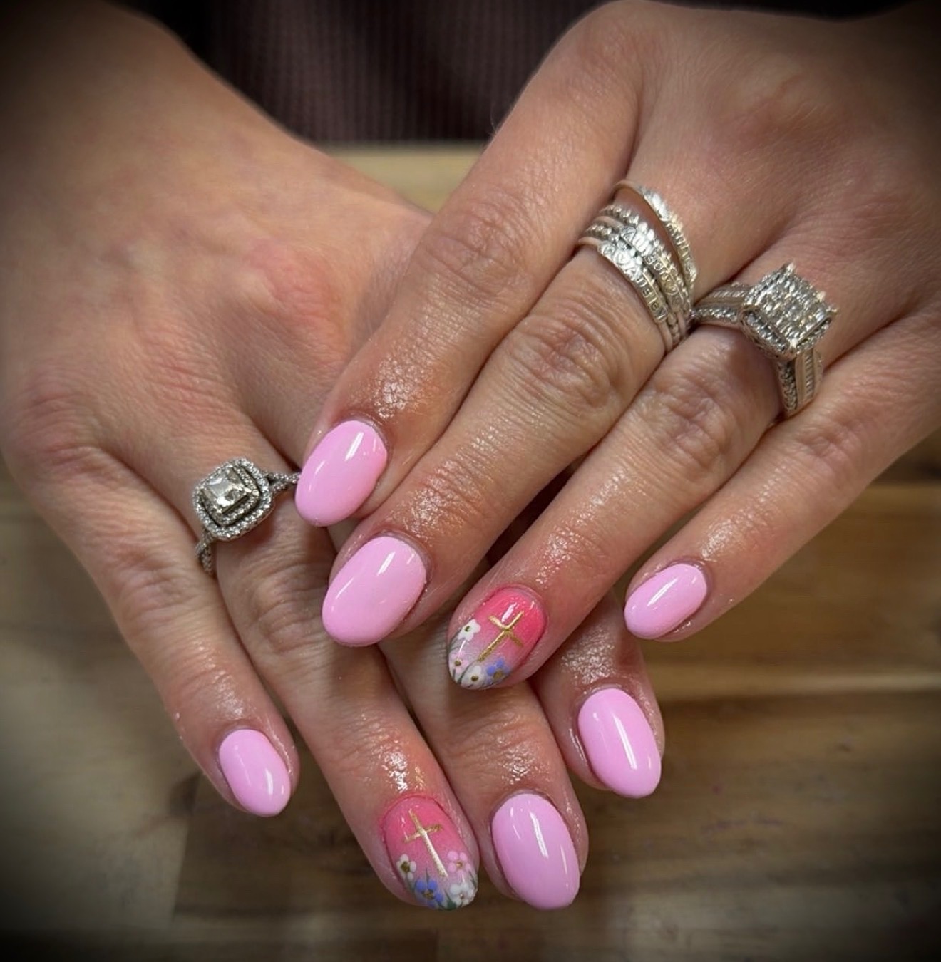 Pink nails with floral and gold cross accents by Tiffany Campbell