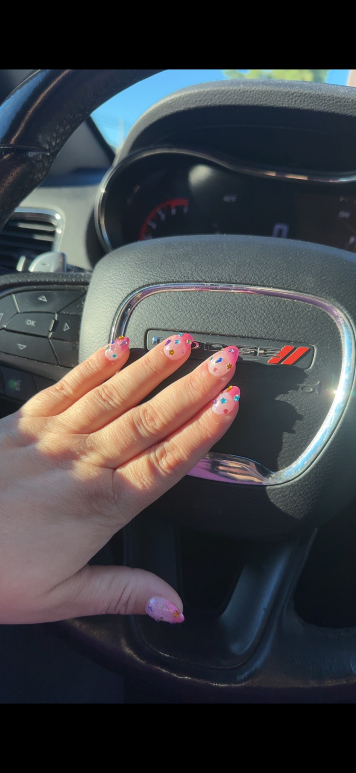Pink nails with colorful gems by Chelsi Troxell