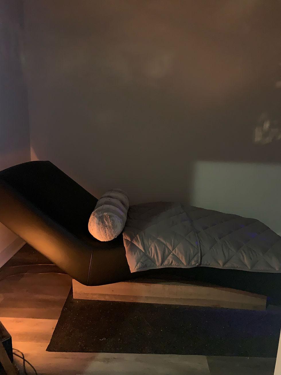 Sound healing binaural beats at Halcyon Floats in Philadelphia PA. Healing station is in darkened room with weighted blanket and pillow.