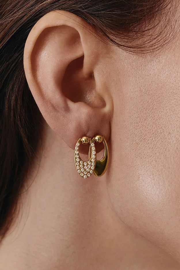Double-sided gold earrings on the earlobe with two piercings