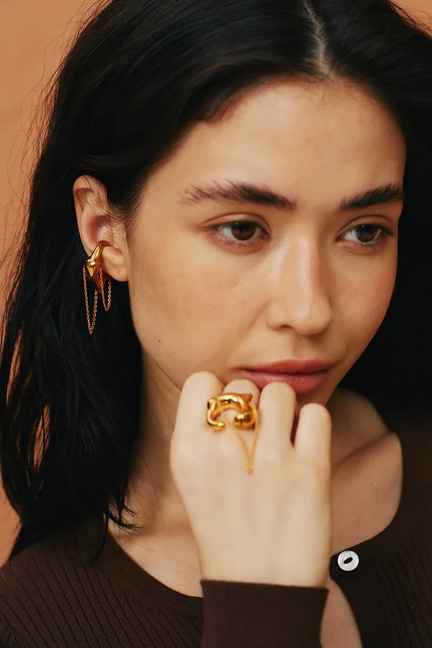 Gold cuff and designer accent ring on a young girl