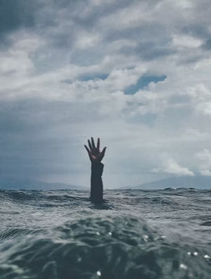 an arm reaching out of the ocean, symbolizing being emotional overwhelmed.