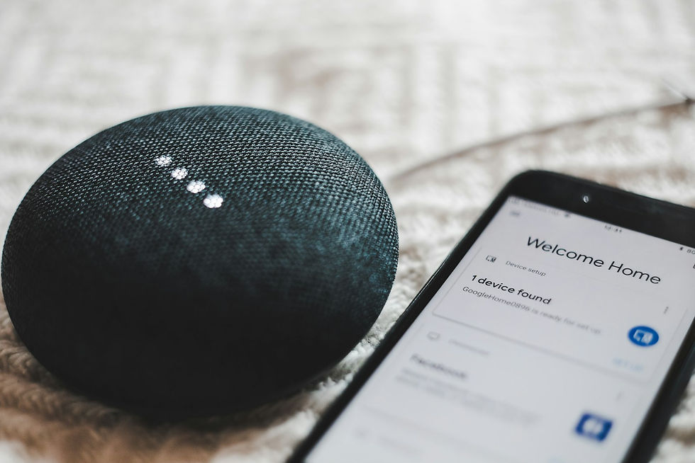 A voice-controlled smart speaker beside a smartphone