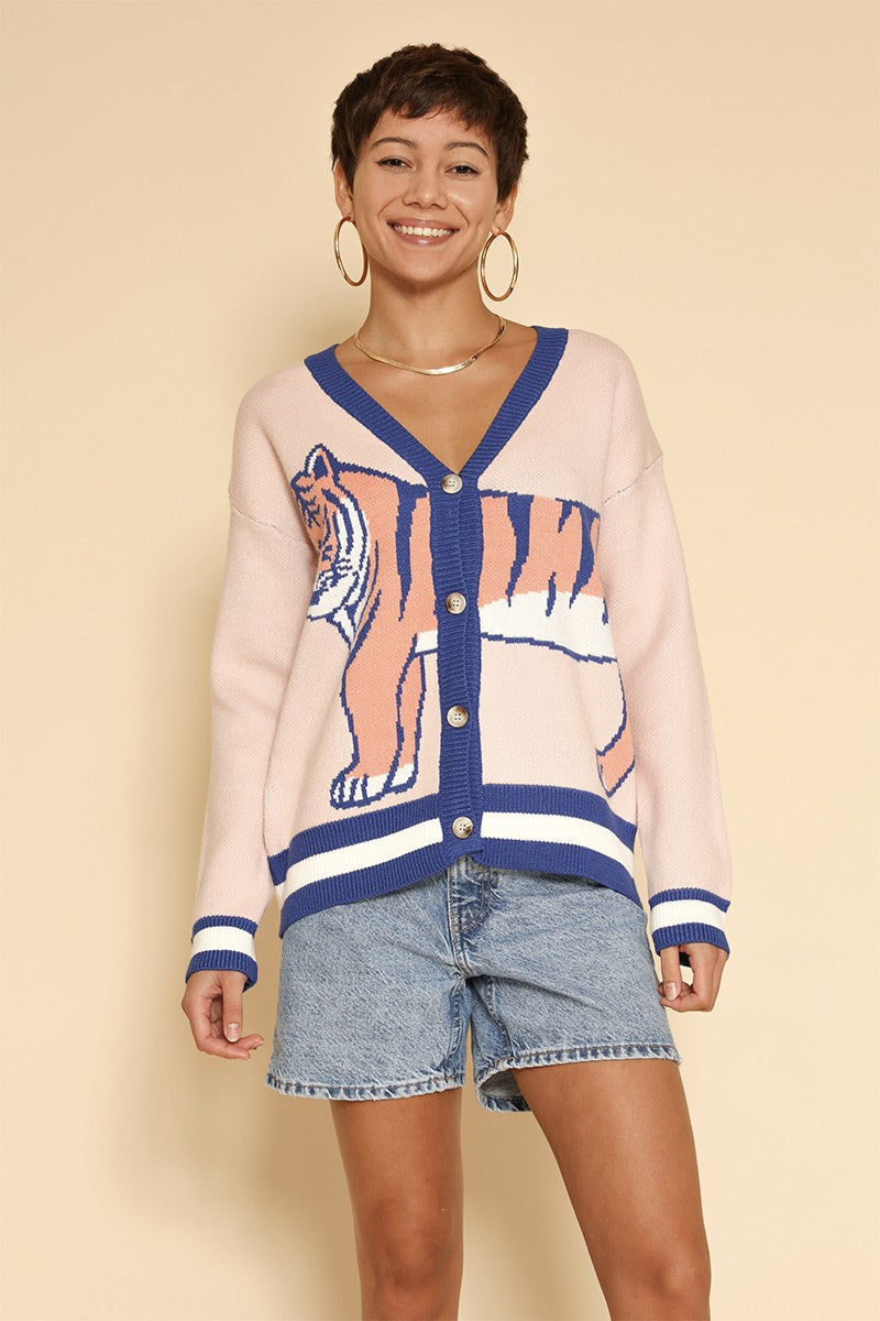 Woman wearing a Tiger Knit Cardigan with denim shorts.