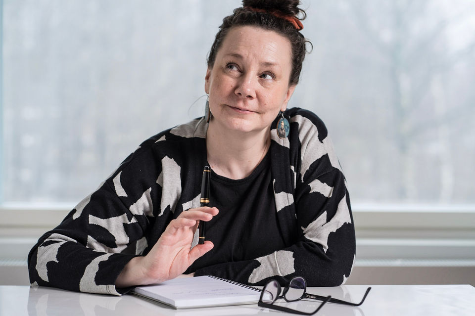 Karoliina kirjoittaa käsin vihkoon pöydän ääressä 