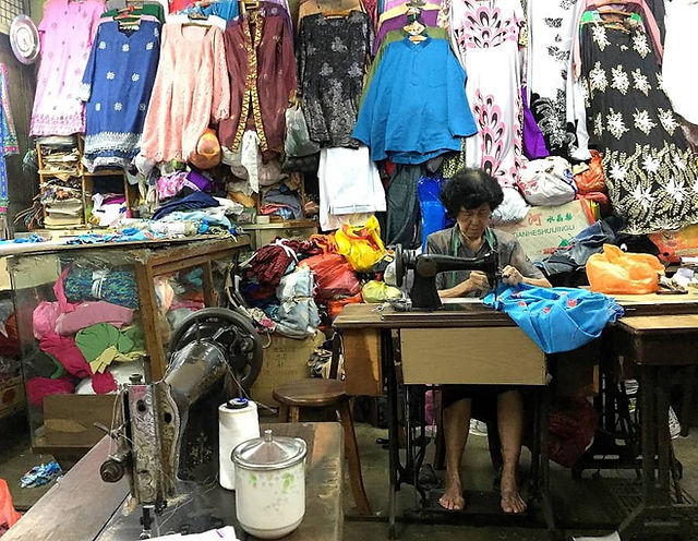 An old tailor working on a customer's order at Kee Ann Road, Malacca.