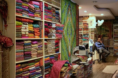 Colourful fabrics stacked in shelves in a textile shop in India