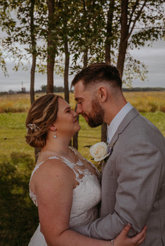 couples portraits on their wedding day in a field of grasses