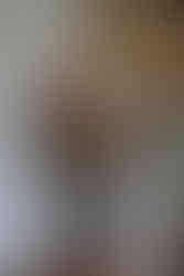 Groom's father holds his leg as they hug while waiting behind a curtain.