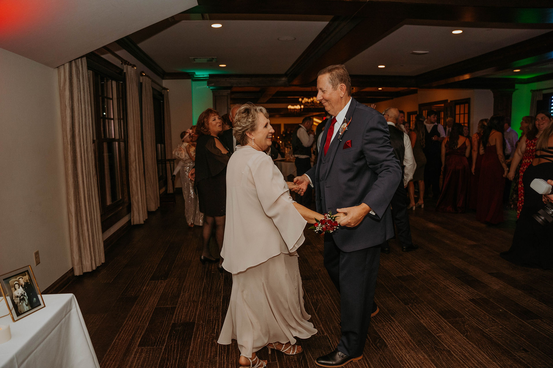 a group of people dancing on the dance floor after dinner at a wedding