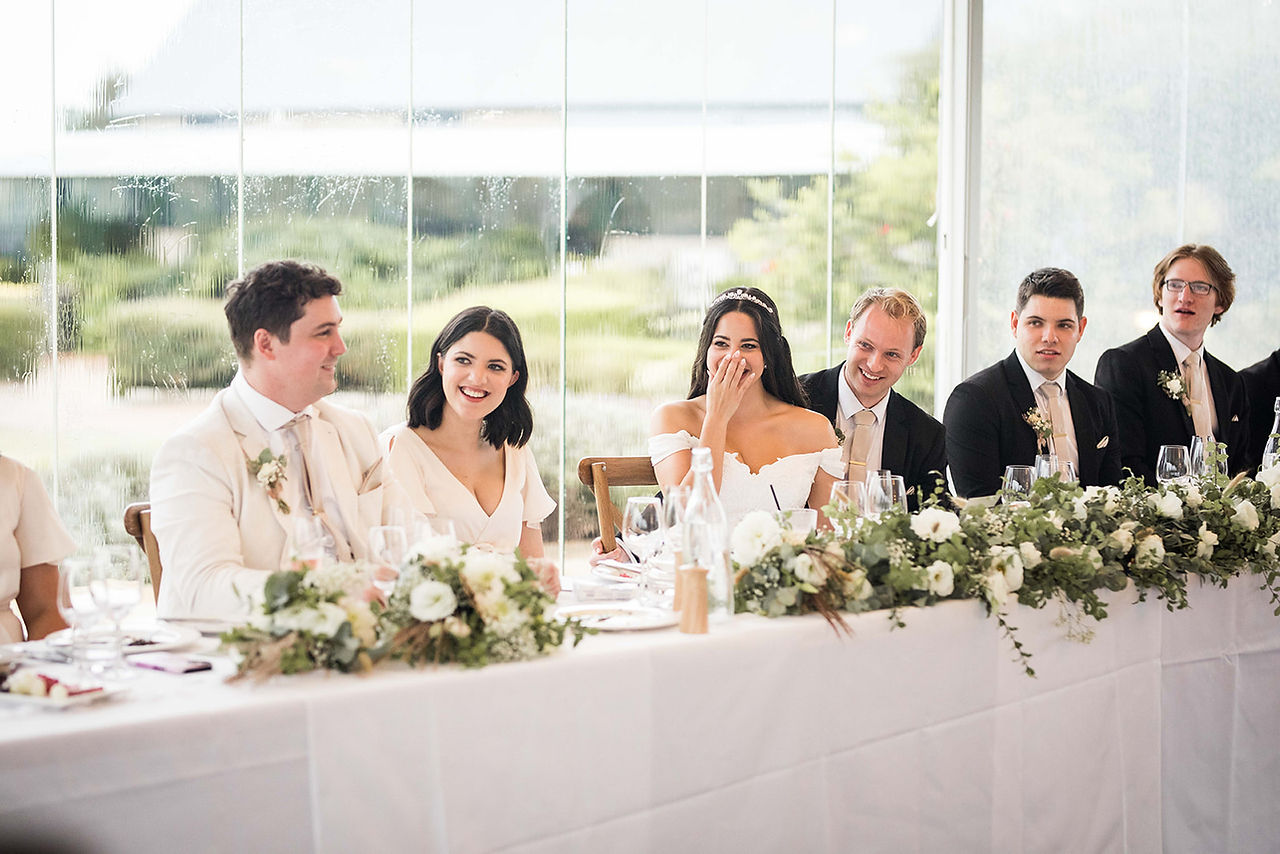 bride laughs at speeches at her wedding reception