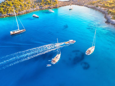 Aerial view of beautiful yachts and boats on the sea at sunset in summer. Akvaryum koyu in