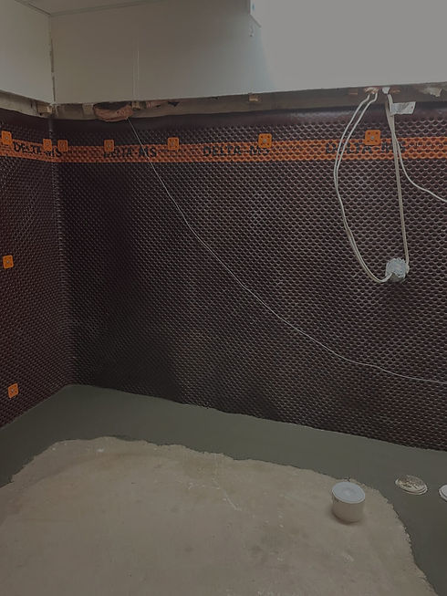 Interior basement waterproofing system with weeping tiles, sump pump, and vapor barrier installation.